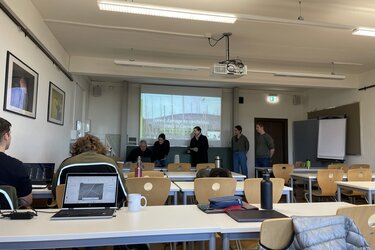 Blick in einen Hörsaal mit der Zoomsitzung auf der Leinwand