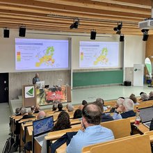 Blick über die Zuhörer hinweg zur Bühne, wo gerade ein Redner spricht