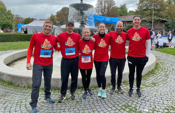 Gruppenfoto der sechs Teilnehmer im Zielbereich. Die Teilnehmer tragen alle ein rotes T-shirt mit der Aufschrift HY-Fire