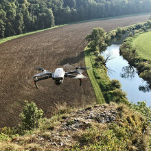 Fliegende Drohne über einem Flusstal