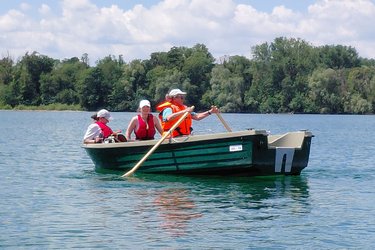 Studierende rudern auf dem See