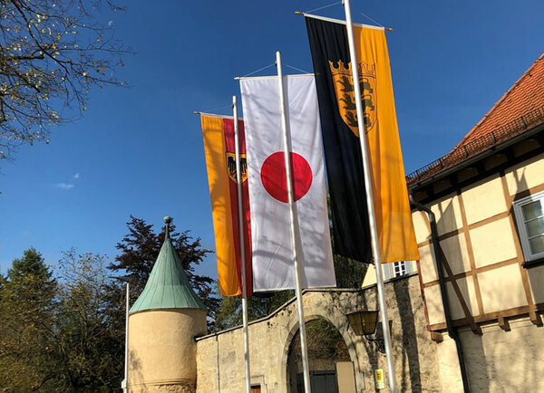 Gehisste Flaggen (Deutschland, Japan, Baden-Württemberg) vor dem Hauptgebäude der Hochschule Rottenburg